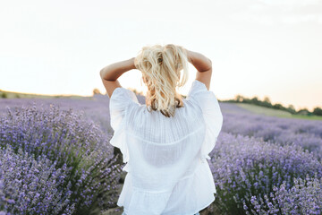 Woman with hands in hair amidst lavender plants