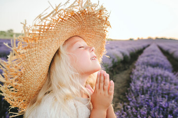 Smiling girl with eyes closed praying in lavender field