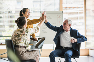 Happy business colleagues giving  high-five to each other at work place