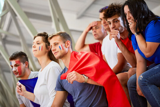 Curious fans with French Flag watching sports event at stadium