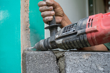 Technicians use a drill to drill holes in the masonry to strengthen the structure in the...