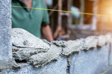Workers use trowels to construct walls or walls with bricks and mortar.