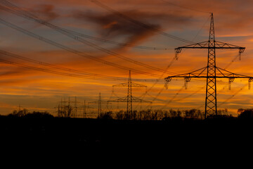 Power grid High power electricity poles in the sunset. Energy supply, distribution of energy, transmitting energy, energy transmission, high voltage supply.