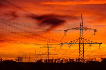 Power grid High power electricity poles in the sunset. Energy supply, distribution of energy,...