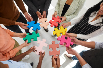 Closeup top view of diverse businesspeople connect jigsaw puzzle pieces motivated for shared...