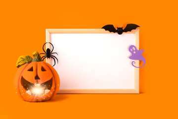 Halloween holiday concept. Jack o lantern, light, handmade paper decorations, spider, ghost, bat and blank frame on orange background. Halloween festival party, greeting card with mockup copy space.