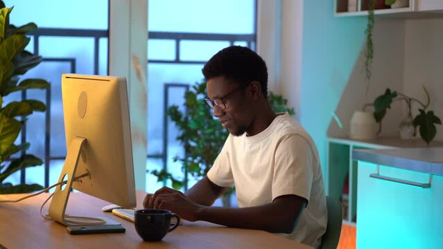 Happy smiling it specialist enjoy working from home on new remote project. Successful african web developer coding new program, website or software. Young freelance programmer on distance occupation