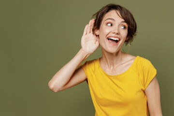 Young curious nosy smiling happy woman she 20s wear yellow t-shirt try to hear you overhear...