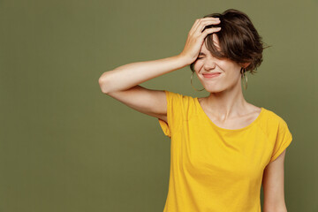Young mistaken sad woman she 20s wear yellow t-shirt put hand on face facepalm epic fail mistaken omg gesture isolated on plain olive green khaki background studio portrait. People lifestyle concept.