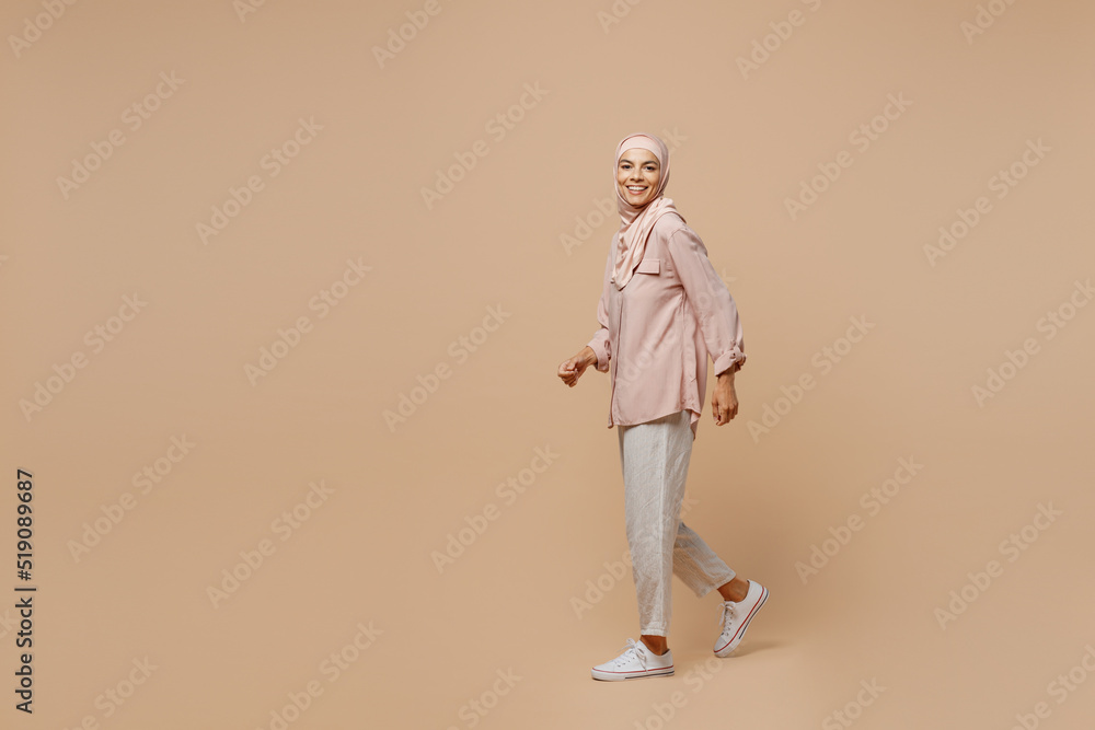 Wall mural full body young arabian asian muslim woman she wear abaya hijab pink clothes walking strolling going