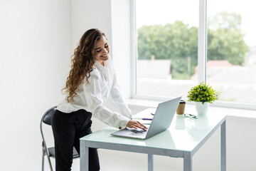 Confident businesswoman working on laptop at her workplace at modern office.