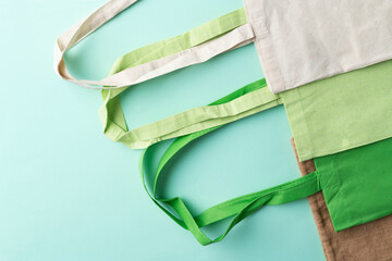 Reusable, eco friendly cotton and jute bags on the green background. Zero waste, climate neutral concept.