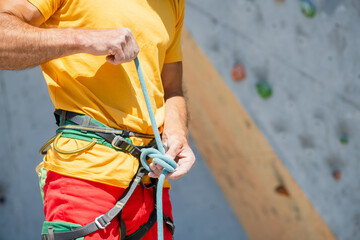 A man prepares to climb a climbing route. Insurance and safety in rock climbing.