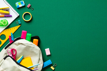 Back to school concept. Colorful school stationery with backpack on green background. Flat lay, top...