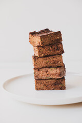 Delicious freshly baked vegan gluten free chocolate brownies made with natural ingridients such as almond flour, banana and zucchini. Sweet healthy food. Alternative sugar free snack.