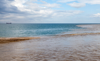 Muddy waters of Belbek river mixing with blue seawate