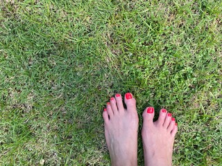 Bare foot on the green grass in sunshine summer day