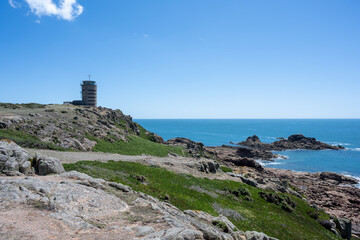 Fototapeta na wymiar The iconic WW2 La Corbiere watchtower on the headland of St Brelade, Jersey, Channel Islands, British Isles.