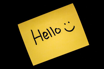 Close-up selected focus isolated Yellow Sticky note with hello greeting and smiley face written on...