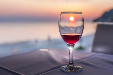 Romantic glass of wine on the beach at sunset