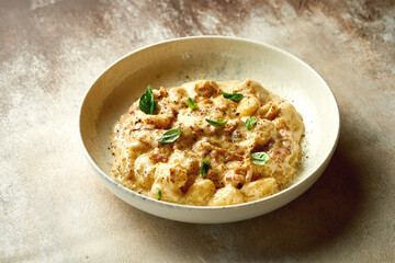 Gnocchi in cheese sauce with bacon on the plate. A selective trick. Close-up