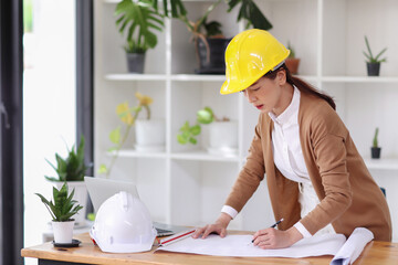 architect or engineer woman asian working on blueprint architects project in office.