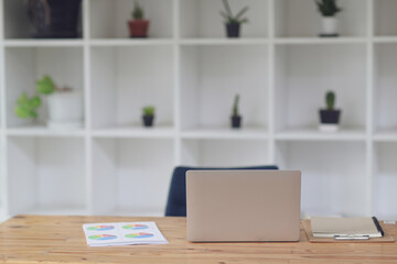 Laptop and documents on wooden  table.