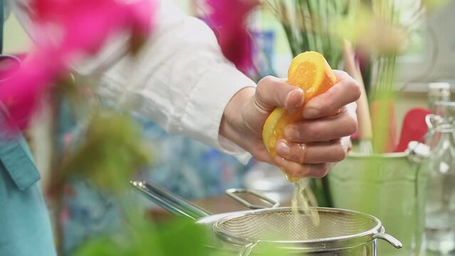Female hand squeezing an orange.
