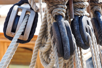 Ship rigging, shrouds of an old wooden ship closeup. Old wooden deadeye on the shrouds of a sailing...
