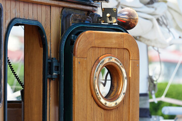 Wooden entrance in the wheelhouse cabin with porthole of an old fishing schooner © ANGHI