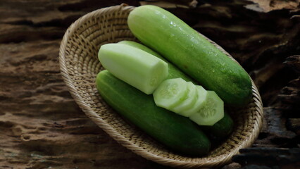 Cucumber in a basket on wooden background