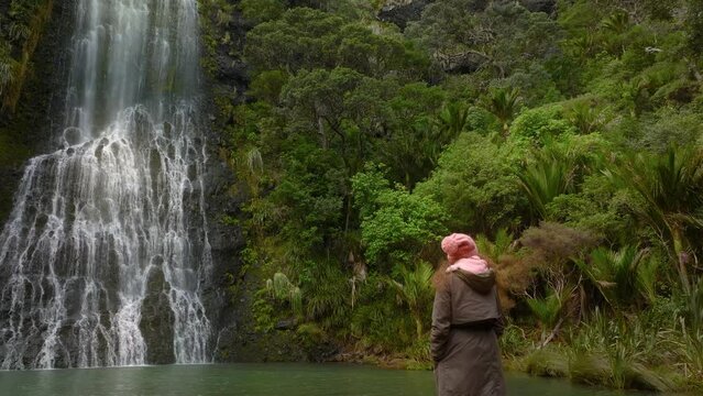 Female visiting Karekare falls, west Auckland, New Zealand