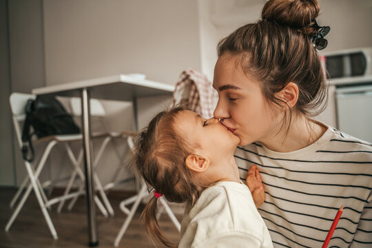 Affectionate mother kissing her cute little daughter on the lips