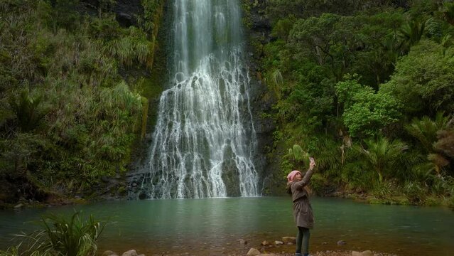 Female visiting Karekare falls, west Auckland, New Zealand