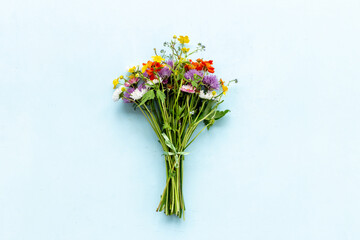 Bunch of wild meadow flowers and herbs chamomile, cornflower and ranunculus. Summer floral background