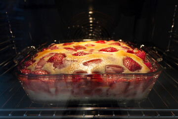 Baking strawberry pie in the clear glass oven dish. Closeup