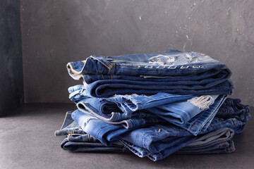 Blue jeans denim heap on table background. Jeans fabric stack as material surface