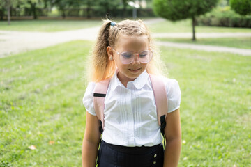 blonde schoolgirl in glasses white shirt with pink backpack back to school