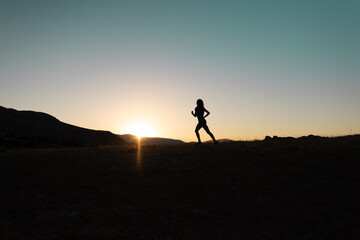 Fototapeta na wymiar girl runs at sunset in the mountains.