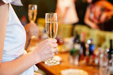 a woman's hand with a glass of white wine. 