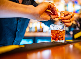 man bartender hand making negroni cocktail. Negroni classic cocktail and gin short drink with sweet vermouth, red bitter liqueur
