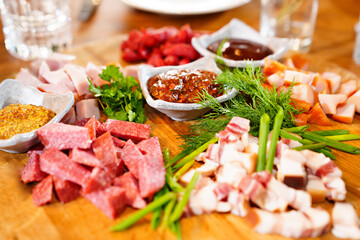 wooden dish with meat cuts, herbs, spices and sauce. 