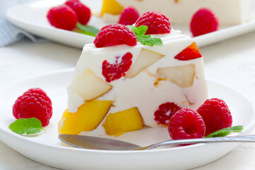 fruit dessert. ice cream with pieces of fruit and ripe raspberries on a white dish