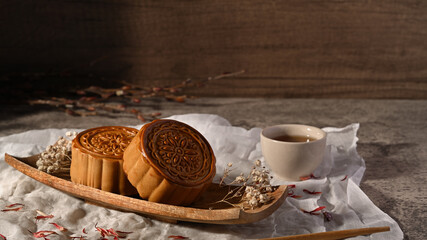 Tasty mooncakes and cup of tea on wooden table, for Mid autumn festival or Chinese traditional festival