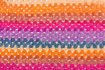 Knitted with colored woolen threads openwork thing macro. Loops, pile, weaving