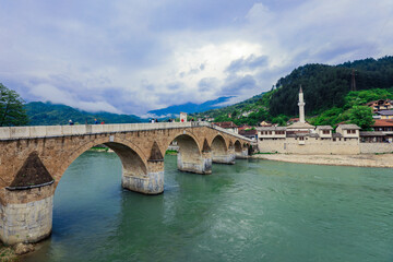 Fototapeta na wymiar View in the Rainy Day to the historic Mehmed Paša Sokolović Bridge Bridge in Višegrad, over the Drina River, Bosnia and Herzegovina