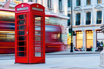 London red telephone booth and red bus in motion