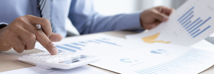 Business men analyze financial graphs and find break-even points for investments in order to reduce costs and reduce corporate taxes, Analysis of financial accounting and real estate investment.