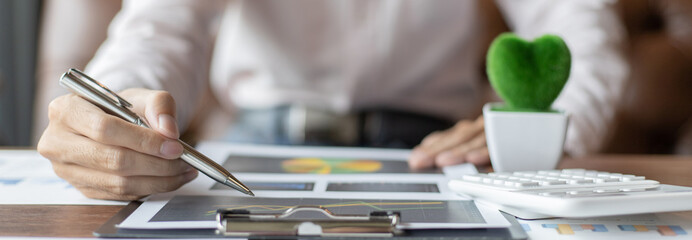 Business men analyze financial graphs and find break-even points for investments in order to reduce costs and reduce corporate taxes, Analysis of financial accounting and real estate investment.