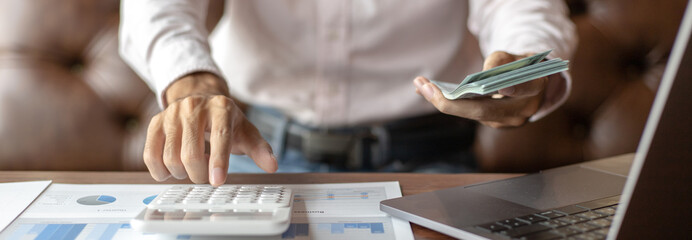 Business men analyze financial graphs and find break-even points for investments in order to reduce costs and reduce corporate taxes, Analysis of financial accounting and real estate investment.